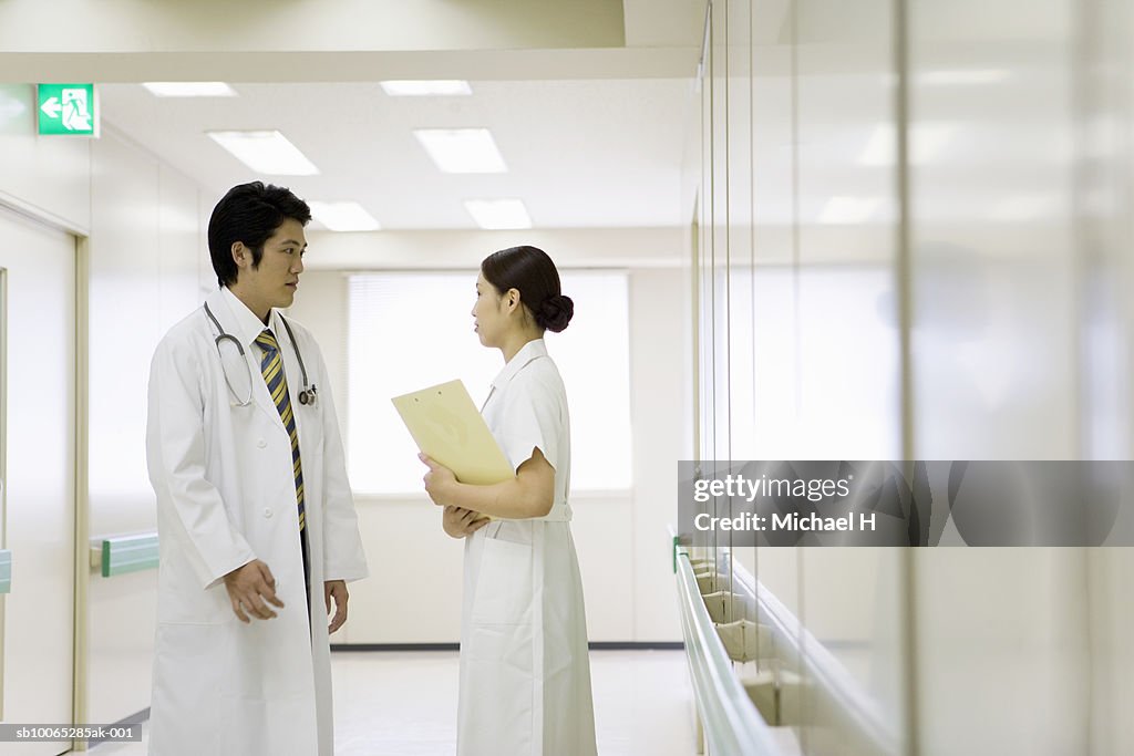 Doctor and nurse talking in hospital corridor