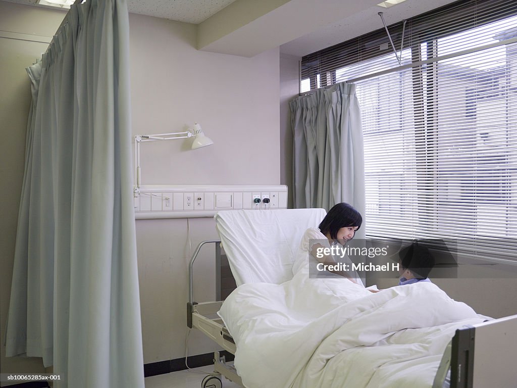 Boy (5-6) visiting mother in hospital room