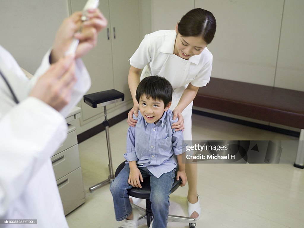 Boy (5-6) with nurse, waiting for injection in hospital