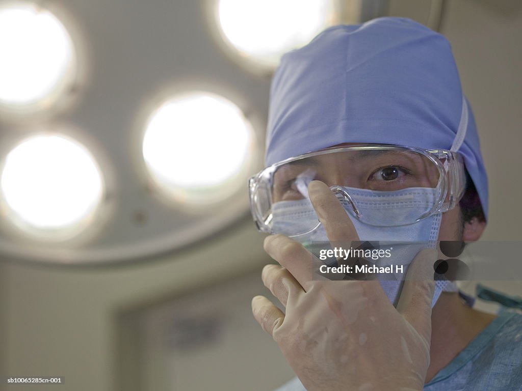 Surgeon adjusting operating glasses, close-up