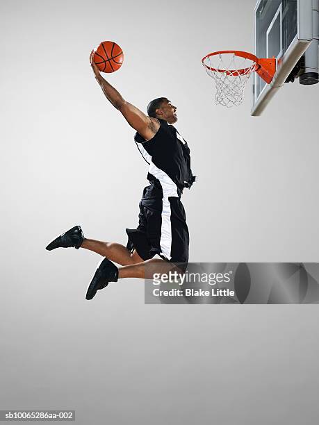 basketball player dunking ball, low angle view - dunk stockfoto's en -beelden