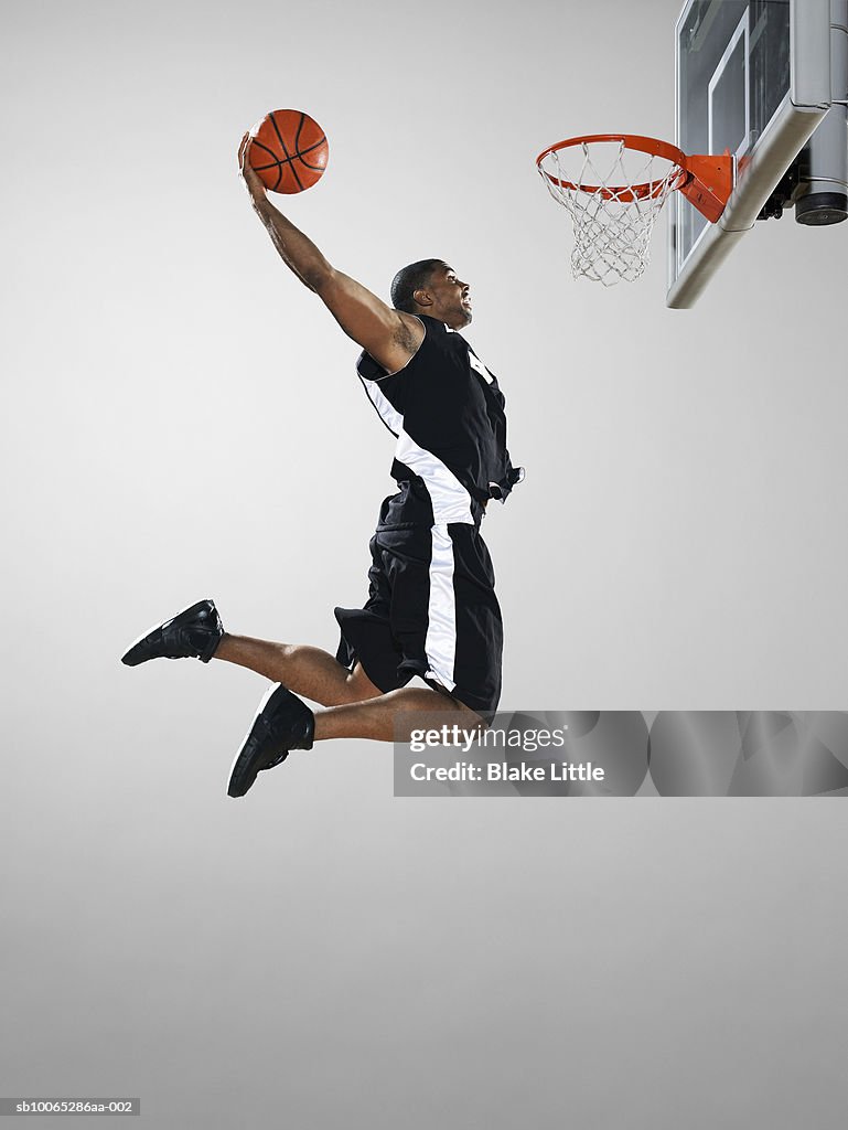 Basketball player dunking ball, low angle view