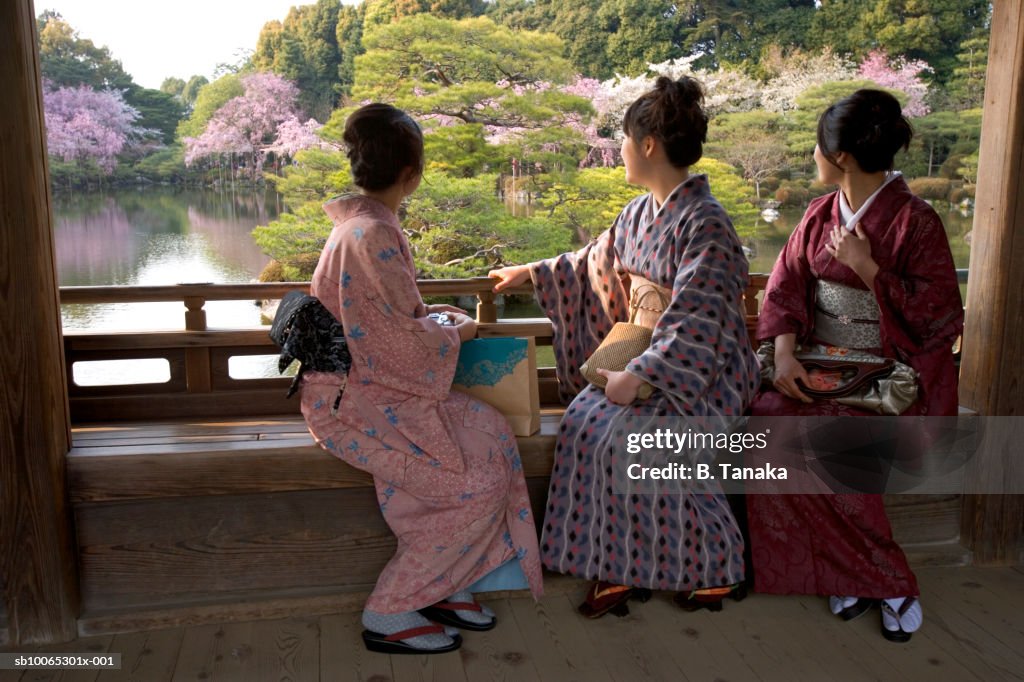 Three women sitting on bench in wooden covered bridge