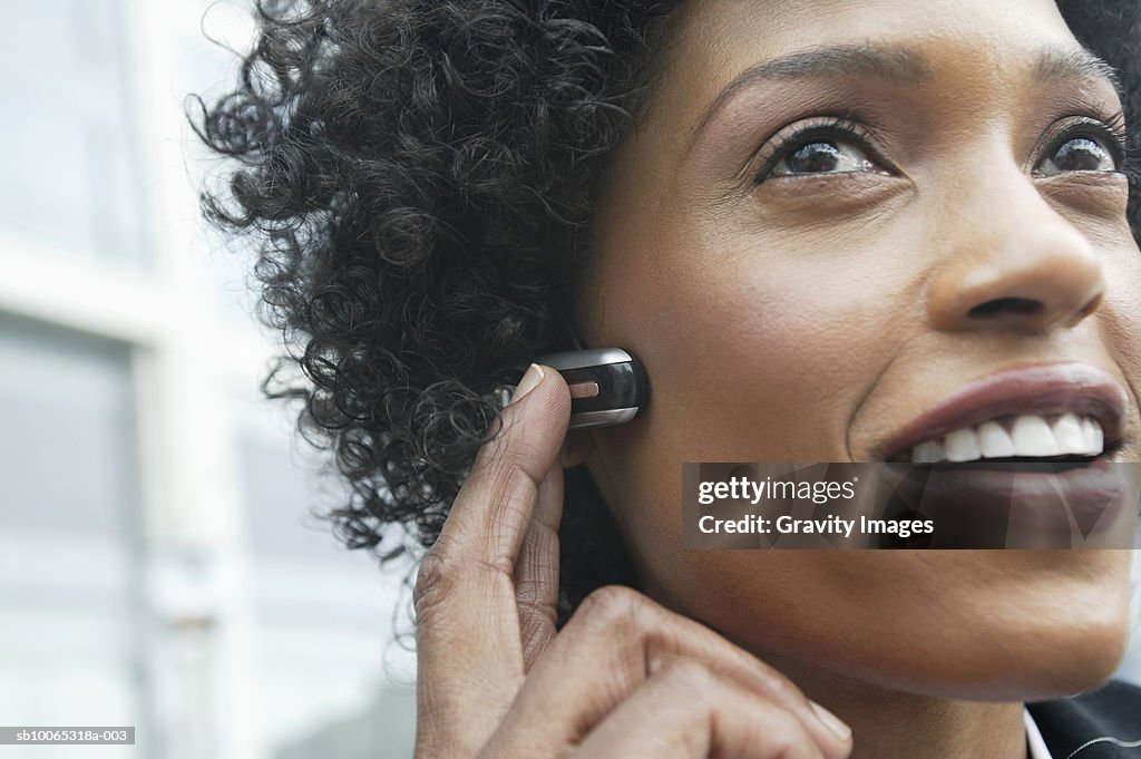 Close-up of young woman using headset