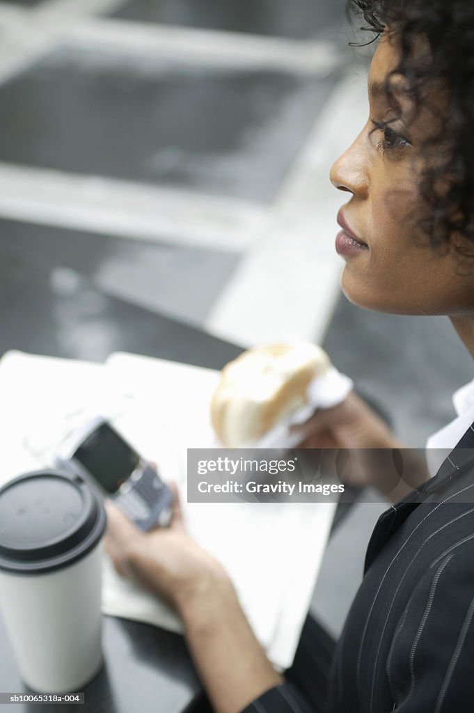 Young business woman having lunch and text messaging