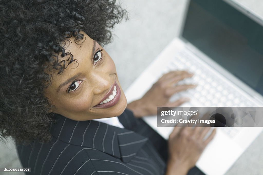 Portrait of young business woman working on laptop, elevated view
