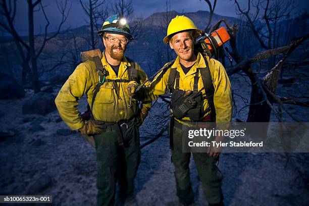 two fire-fighters standing together in burnt forest, portrait - forest firefighter stock pictures, royalty-free photos & images