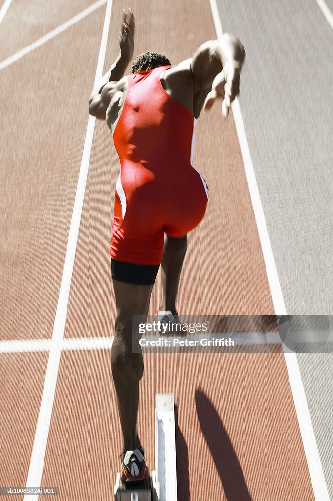 Athlete running on track, rear view