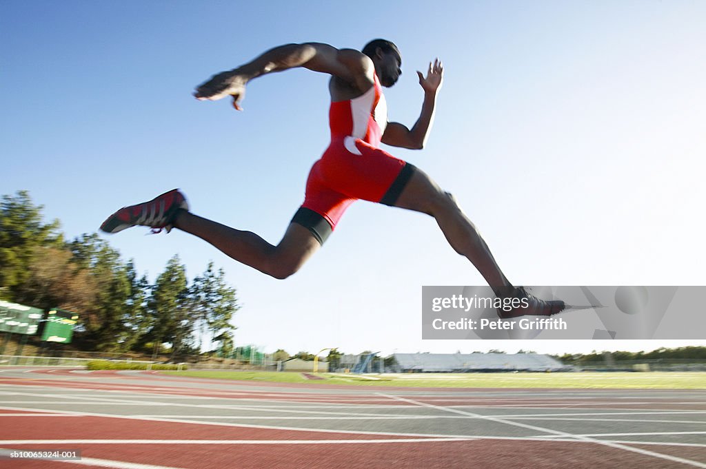 Athlete running on track, side view