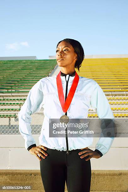 female athlete wearing medal in stadium - athlete medal stock pictures, royalty-free photos & images