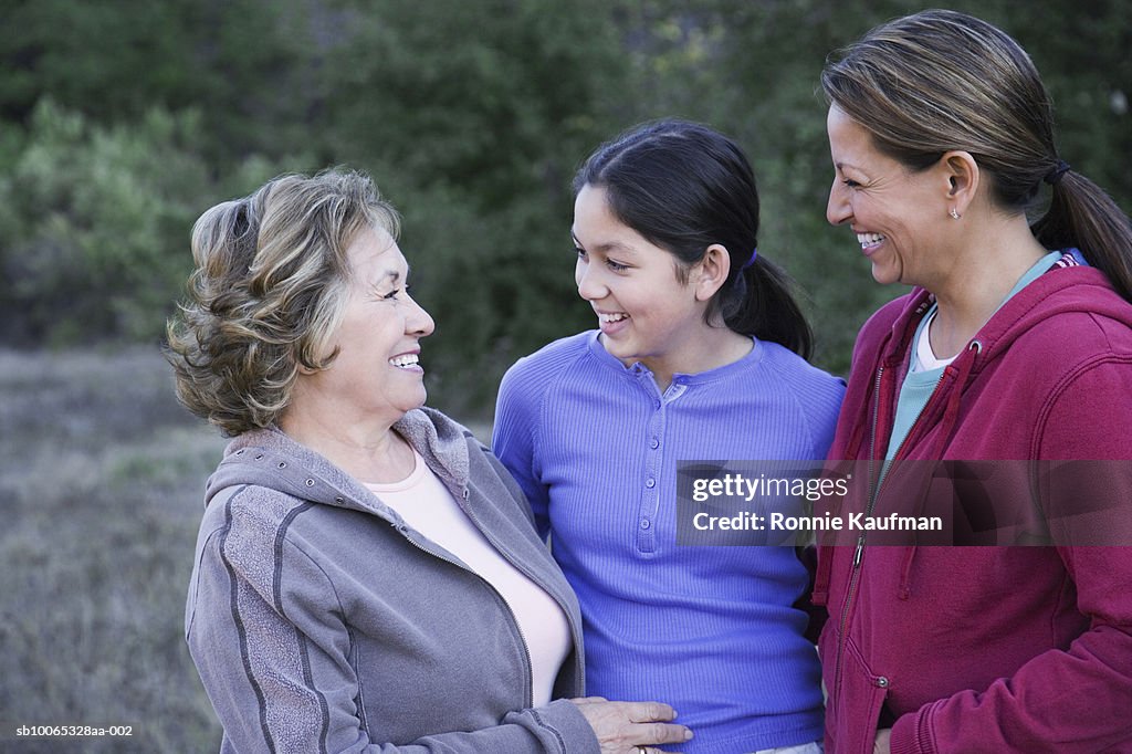 Three women standing in park, close-up