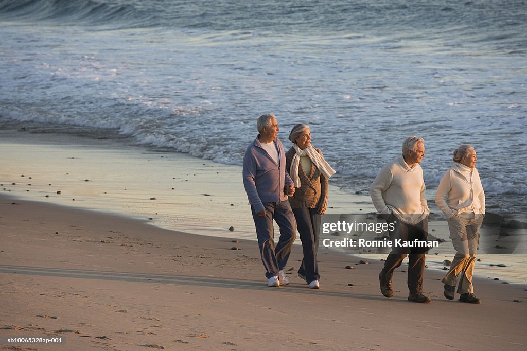 Senior men and women walking at beach