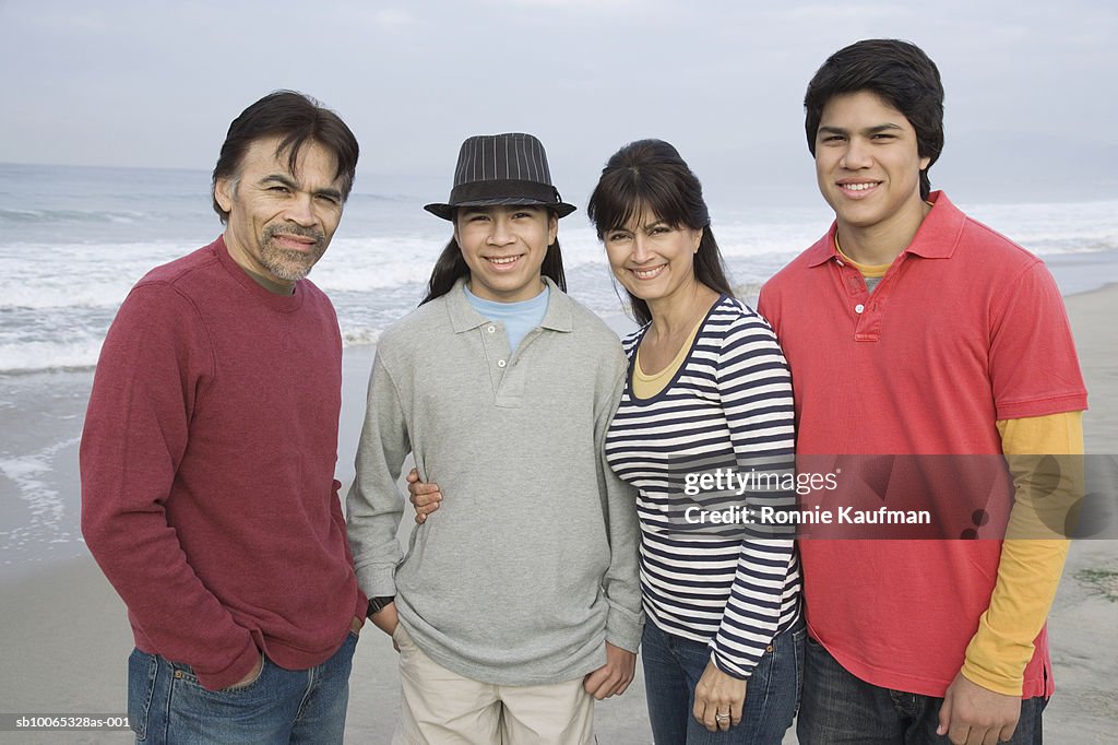 Family standing on beach, portrait, smiling