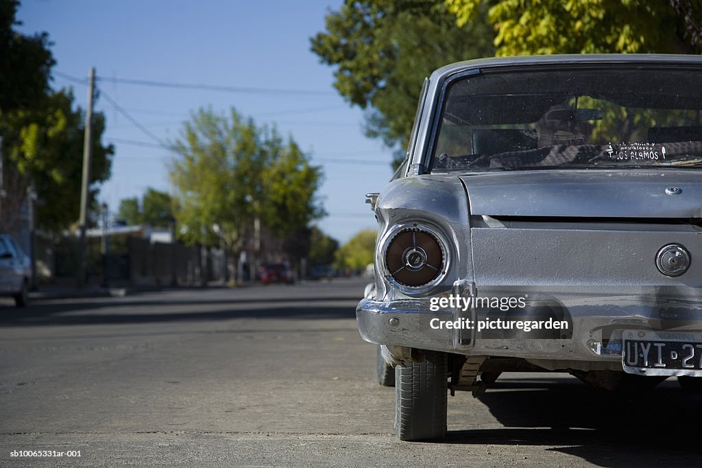 Old fashioned car standing by road