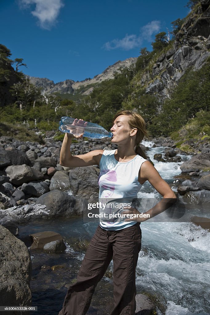 Woman drinking water by stream