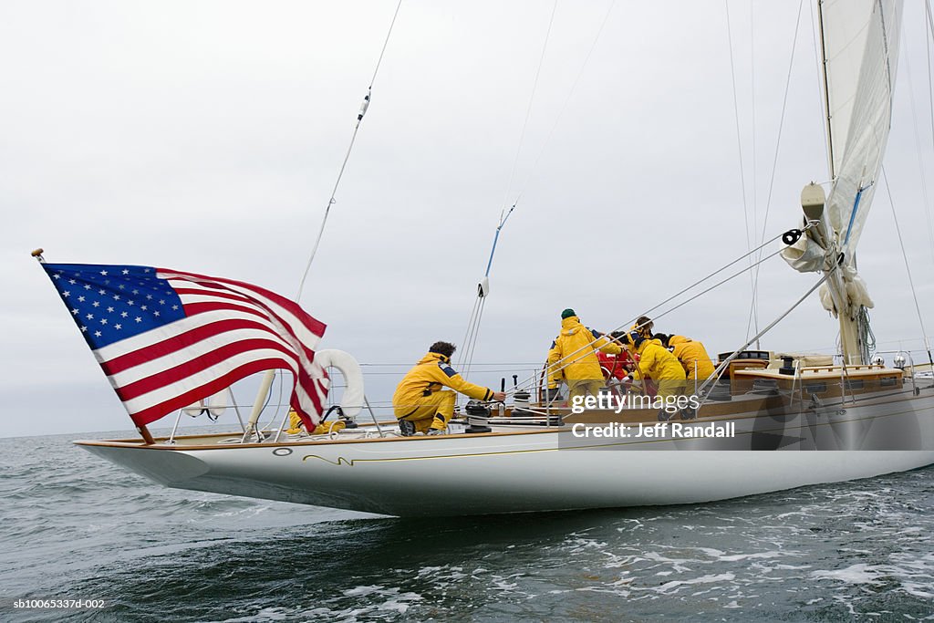Crew sailing racing yacht