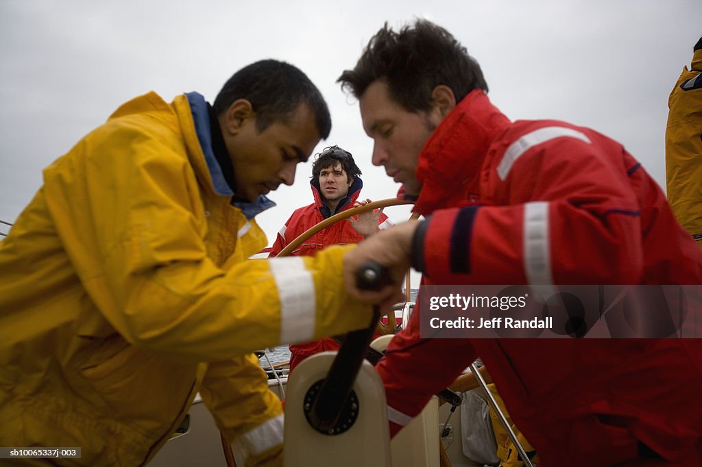 Crew sailing racing yacht