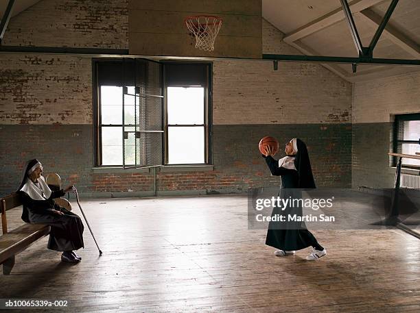 two senior nuns in court, one throwing basket ball - nun habit stock pictures, royalty-free photos & images