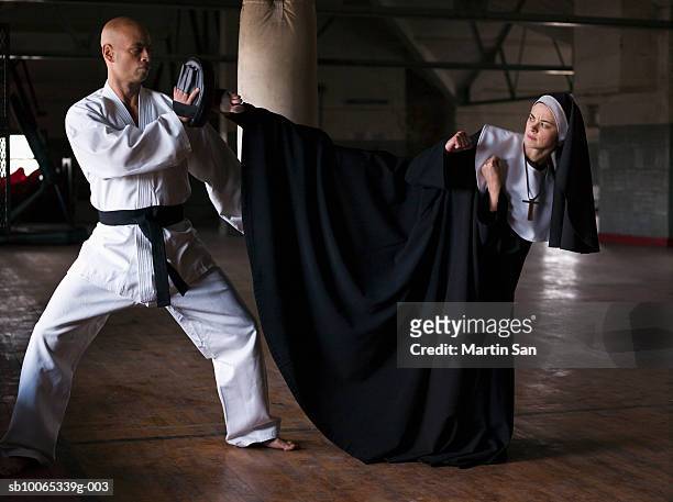 instructor teaching martial arts to young nun - monja fotografías e imágenes de stock