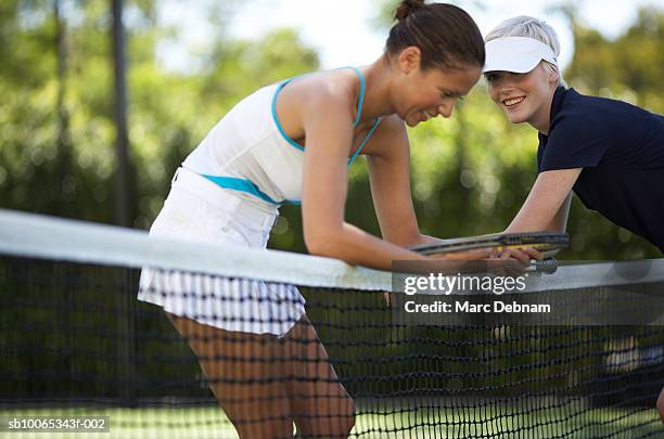 two female tennis players at net on outdoor court - tennis net stock pictures, royalty-free photos & images