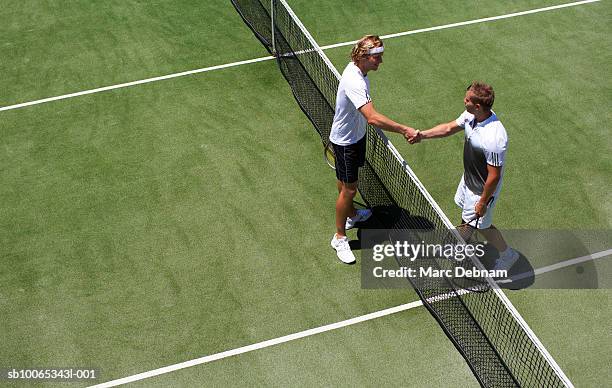 two male tennis players shaking hands over net - tennis net fotografías e imágenes de stock