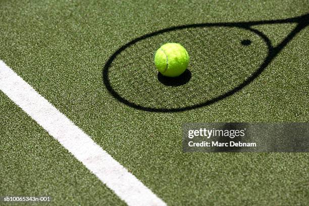 tennis ball with racket shadow on court - balle de tennis photos et images de collection
