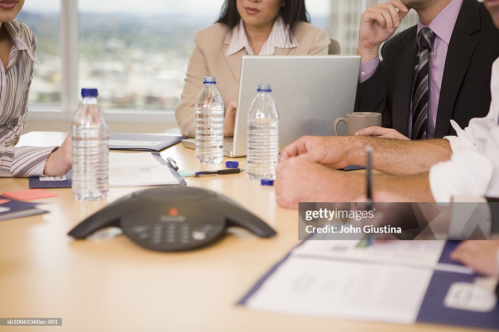 Business executives discussing at conference table (differential focus)