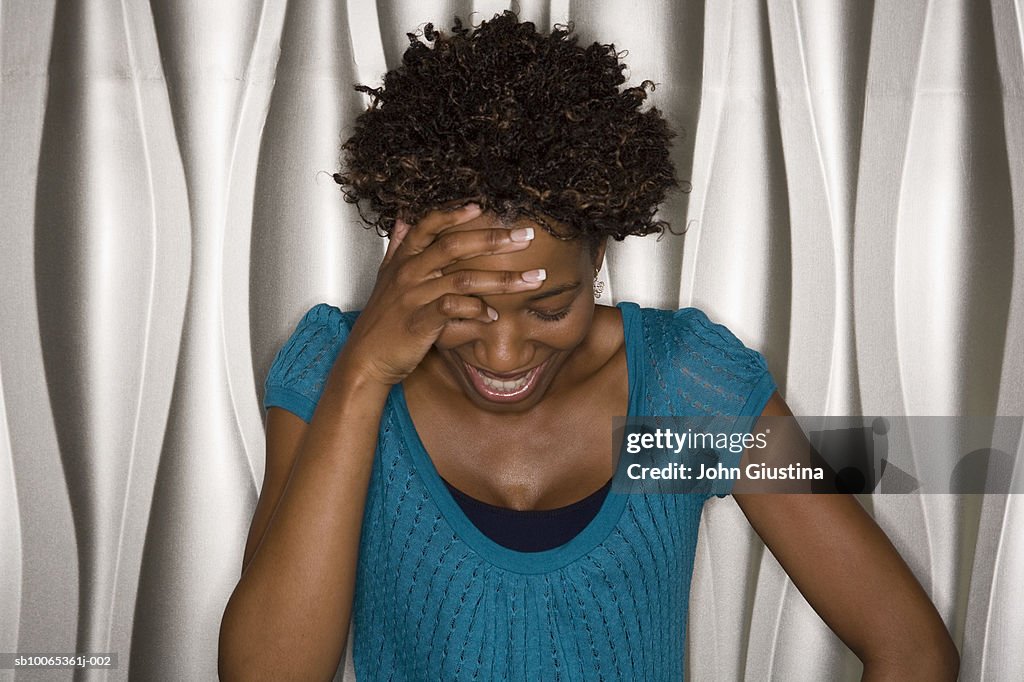 Woman laughing with hand on head