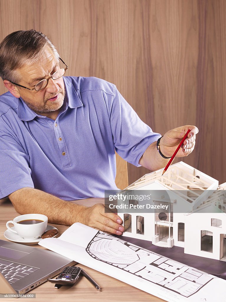 Architect with model house on desk