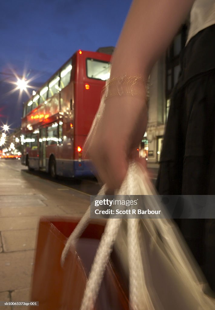 Woman holds shopping bags on Oxford Street in London, England.