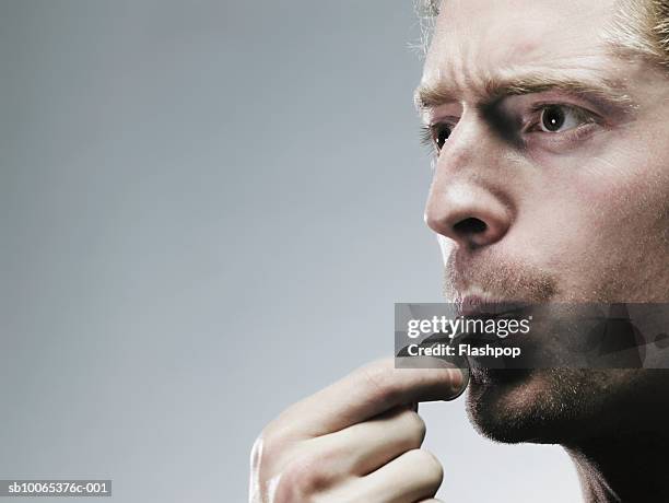 young man blowing whistle, close-up - culotte sur la tête photos et images de collection