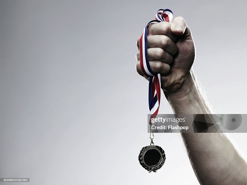 Young man holding medal, close-up