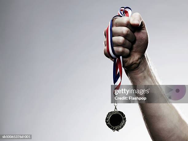 young man holding medal, close-up - medal foto e immagini stock