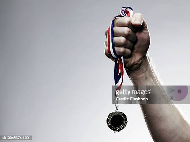 young man holding medal, close-up - medal stock pictures, royalty-free photos & images