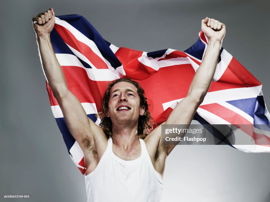 Young man holding flag, smiling, close-up