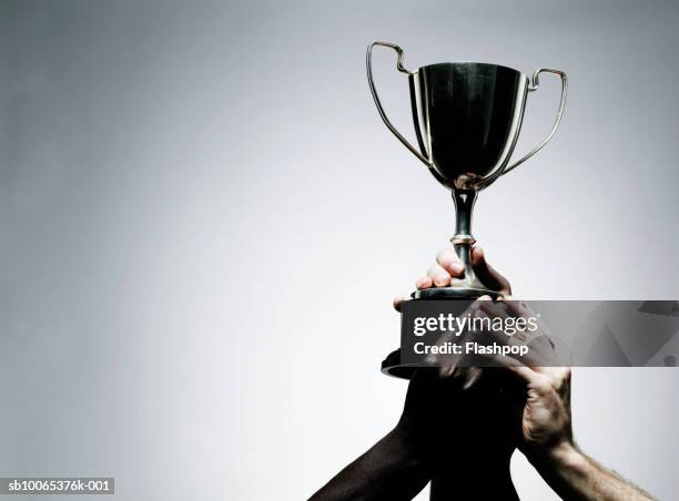 two men holding trophy, close-up - troféu imagens e fotografias de stock