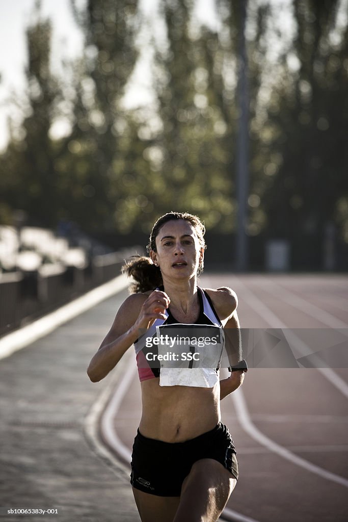 Female athlete running on race track