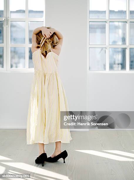 young girl (6-7) wearing mother's dress and shoes, rear view - high heel stockfoto's en -beelden