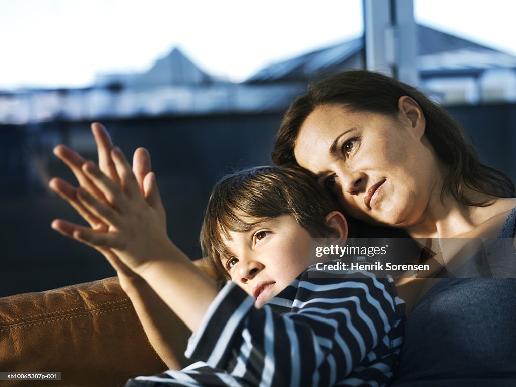 Mother and son (8-9) sitting on sofa, comparing palms