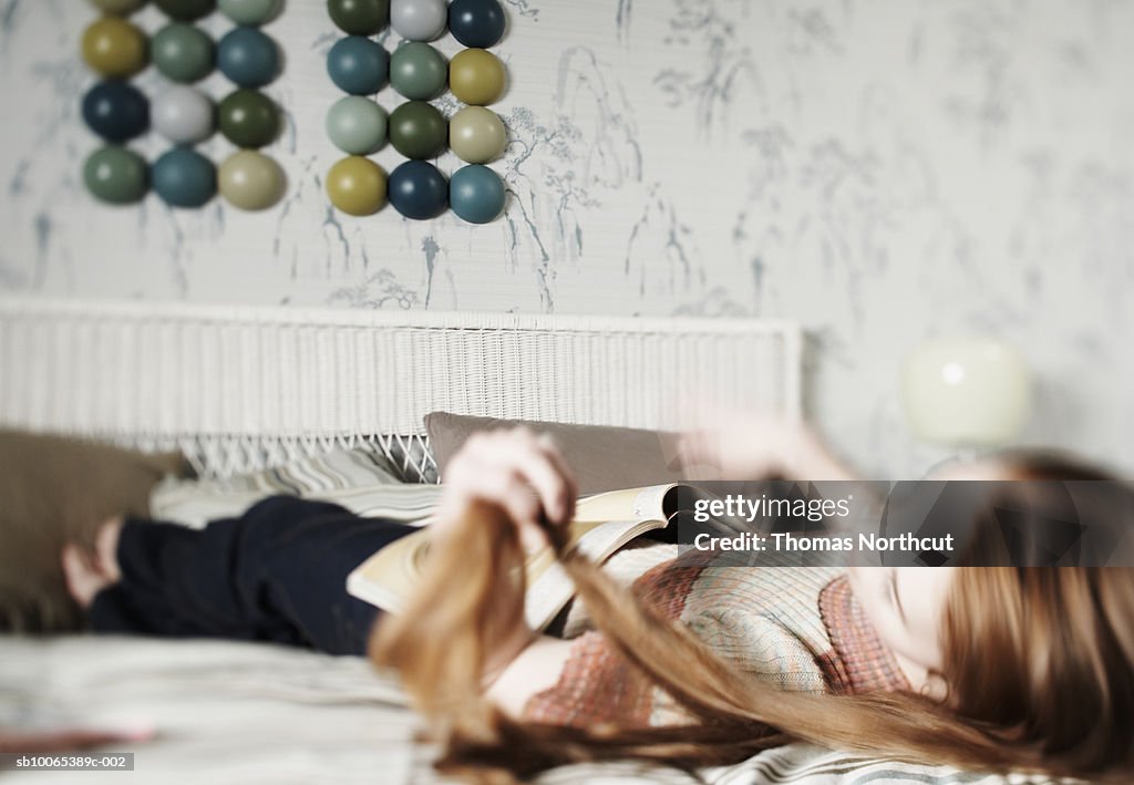 Girl (14-15) lying on bed (defocused)