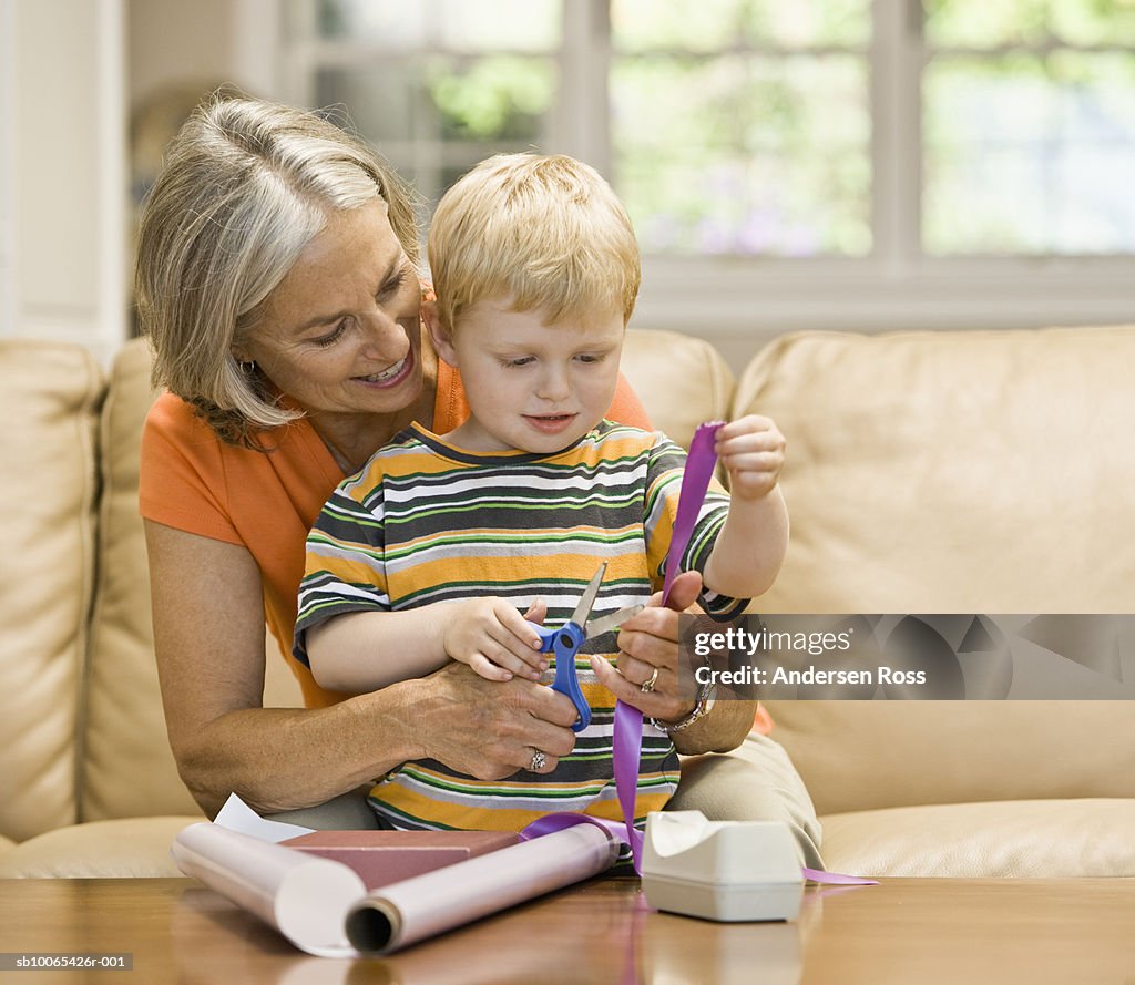 Grandmother with grandson (2-3 years) wrapping gift