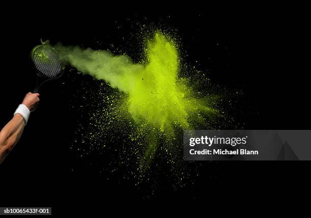 tennis player hitting green powder ball, view of powder exploding, studio shot - tennisball stock-fotos und bilder