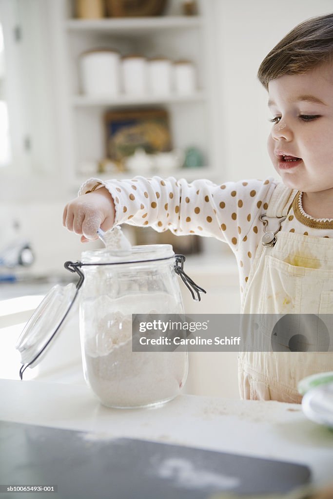 Young girl (2-3) measuring flour in kitchen