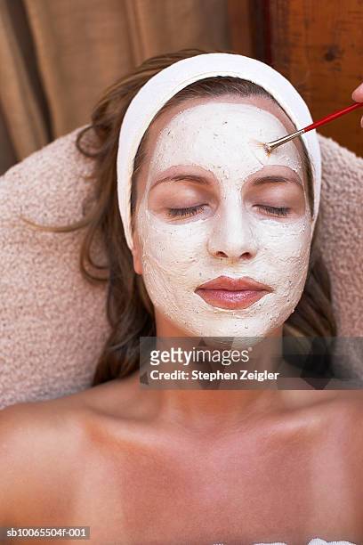 beautician applying clay facial mask to mid adult woman, close-up of finger and brush - clay stock pictures, royalty-free photos & images