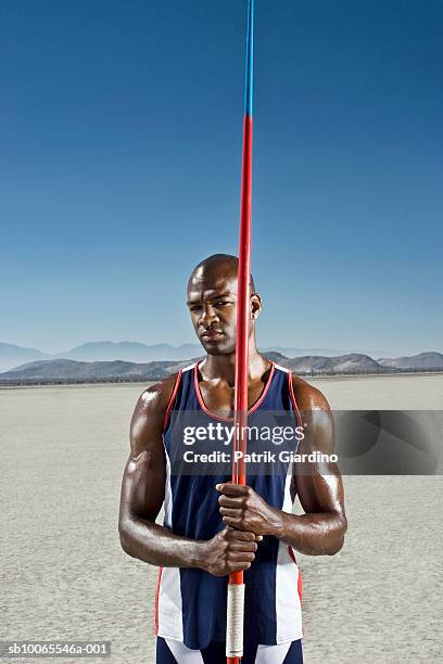 athlete holding javelin, portrait - javelin stock-fotos und bilder