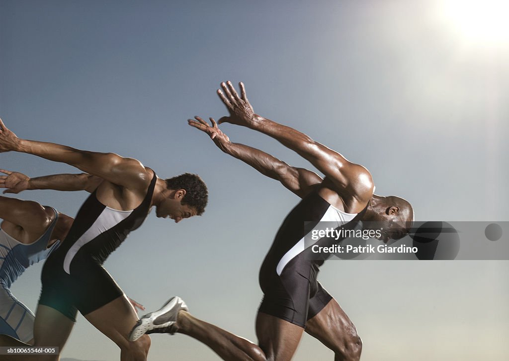 Three athletes running, side view