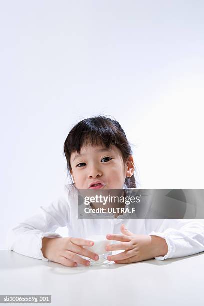 portrait of girl (4-5) with glass of milk, studio shot - milk moustache stock-fotos und bilder