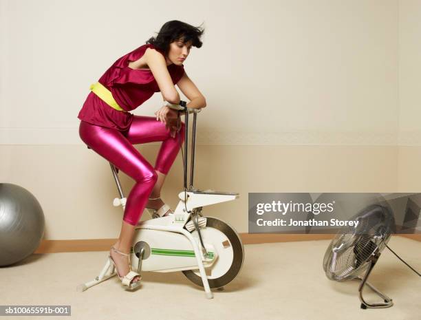 young woman using exercising bike - sloth 個照片及圖片檔