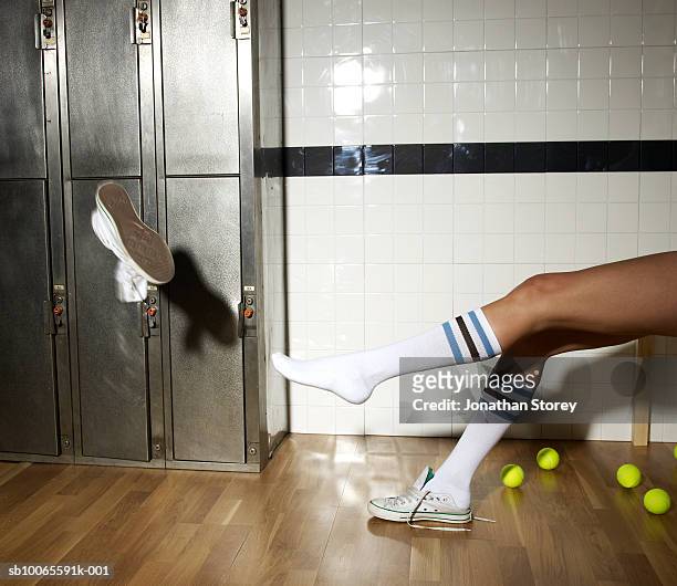 young woman throwing shoes in locker room - white socks stock-fotos und bilder