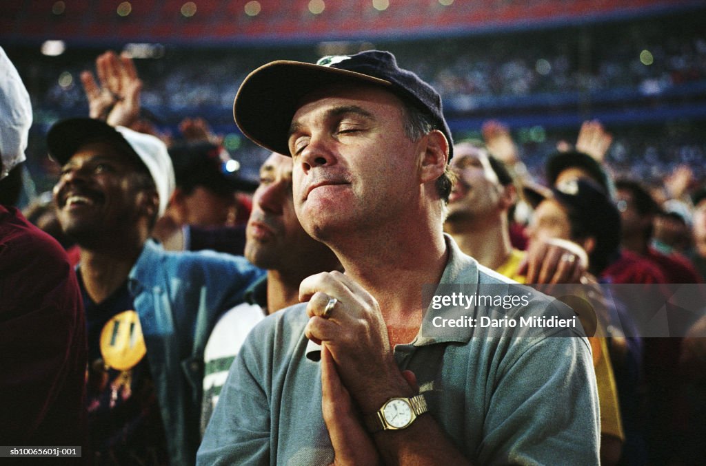 Spectator praying during match